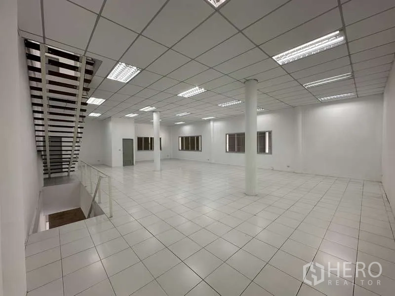 Factory for rent in Khlong Luang, Pathum Thani - Bright tiled mezzanine office floor with grid ceiling lights and stair access.