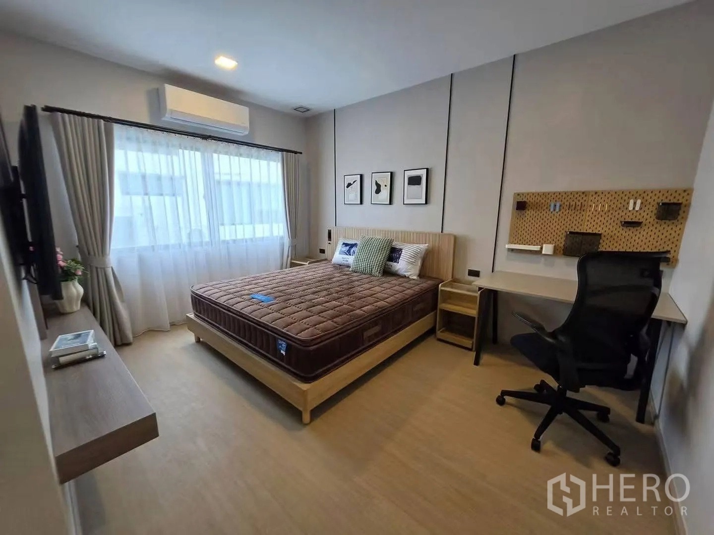 Townhouse for rent in Bang Phli, Samut Prakan - Bright bedroom with bed, desk, wall-mounted TV, and large curtained window.