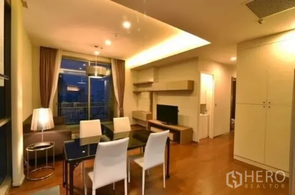 คอนโด ให้เช่าในWatthana, Bangkok - โถงนั่งเล่นและรับประทานอาหารแบบโอเพ่นแพลน โต๊ะสี่ที่นั่ง ผนังทีวี ตู้บิลท์อิน และทางออกสู่ระเบียง