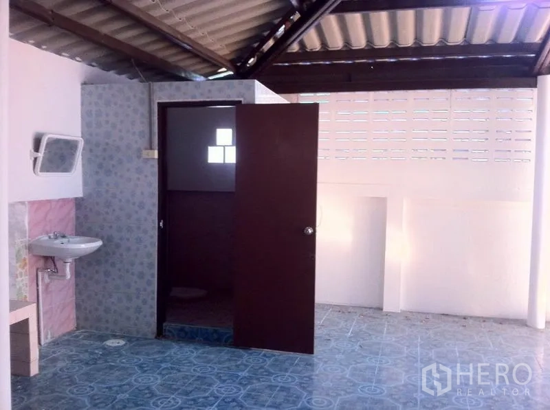 Warehouse for rent in Lam Luk Ka, Pathum Thani - Simple tiled bathroom with a sink and separate toilet under a metal roof.