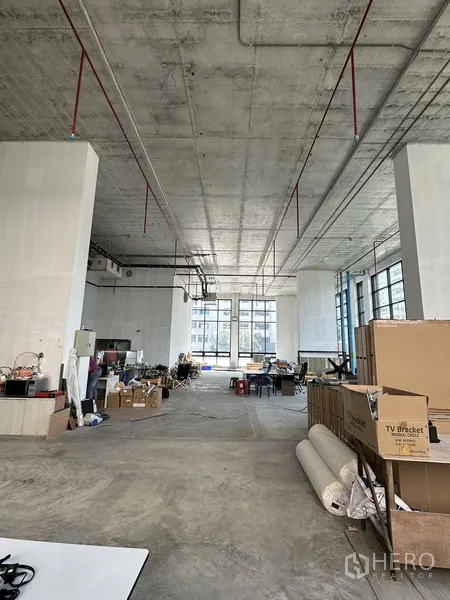 零售空间 出租在Khlong Toei, Bangkok - 宽敞毛坯零售室内，双层挑高天花与外露管线，整面大窗引入充足采光。
