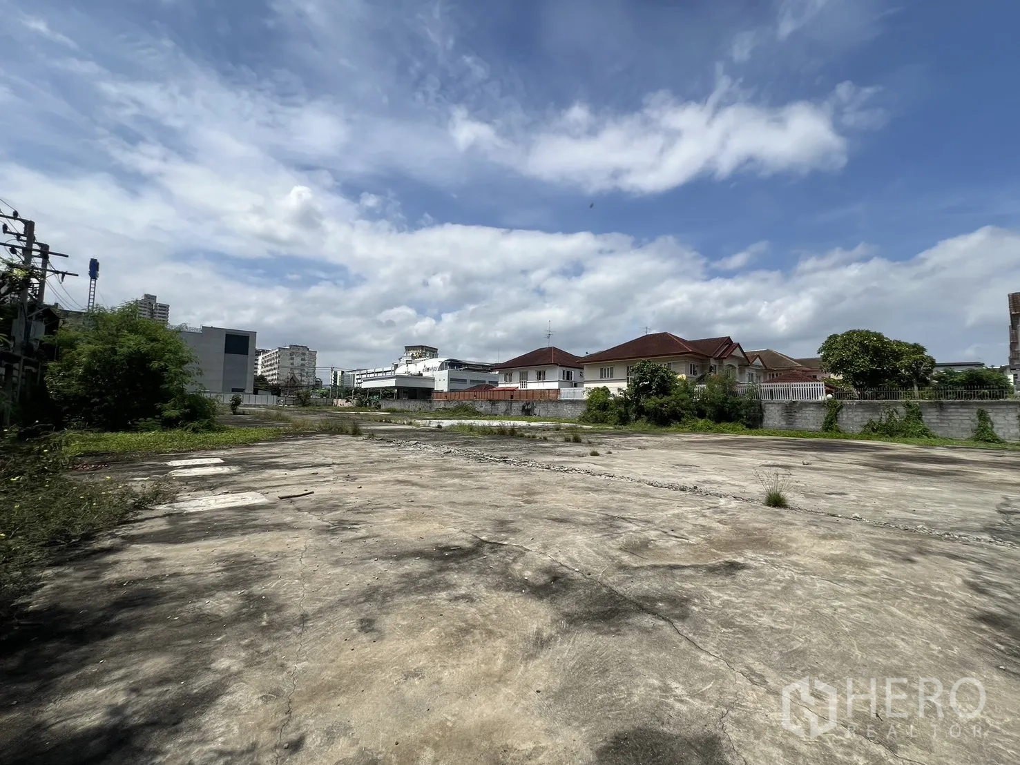 Land for sale in Bang Kapi, Bangkok - Large level site with concrete base, city buildings and greenery around the perimeter.
