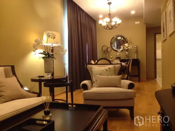 Condominium for rent in Khlong Toei, Bangkok - Warm Sukhumvit condo living and dining area with chandelier, wood floors and elegant decor.