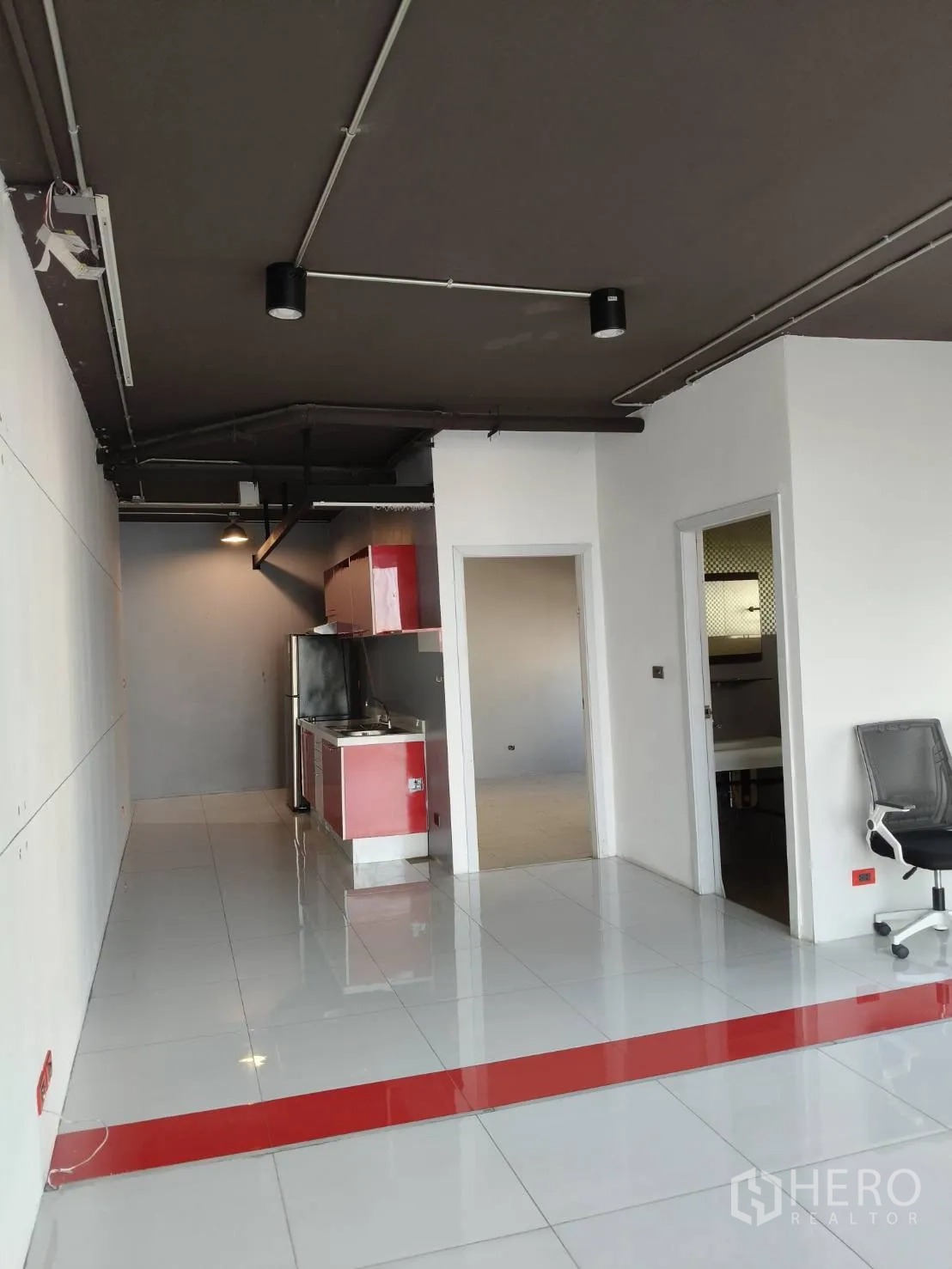 办公空间 出租在Khlong Toei, Bangkok - 入口区域，红色茶水间、通往各房的门与抛光地砖。