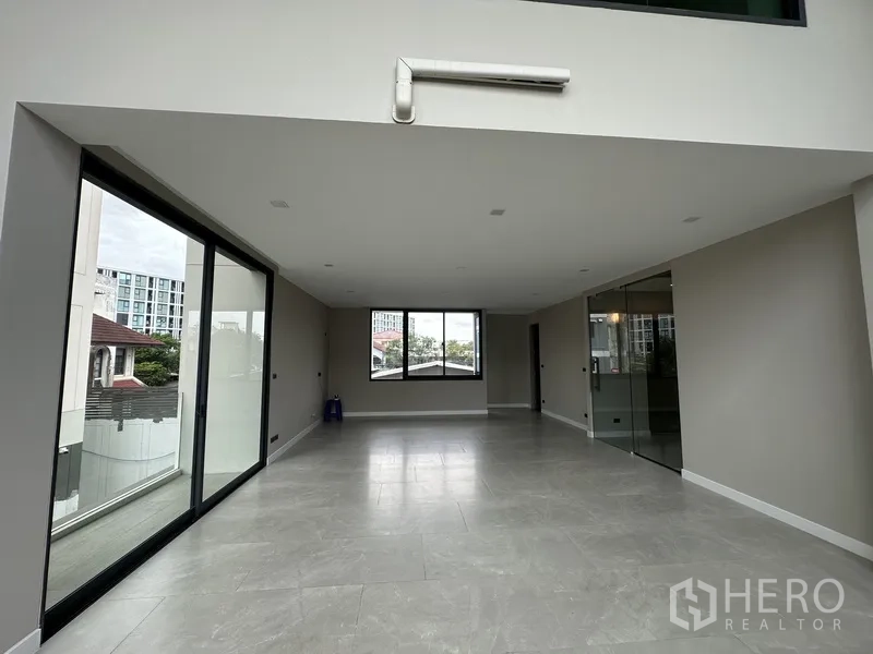 家庭办公室 for rent or sale in Suan Luang, Bangkok - 宽敞大厅，推拉门连通露台，旁有玻璃隔间。