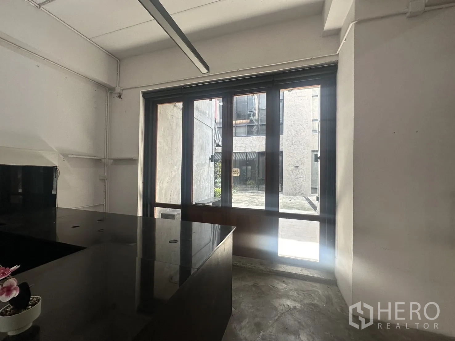 带办公室的家 出租在Pathum Wan, Bangkok - 采光充足的工作区，落地窗与黑色操作台。