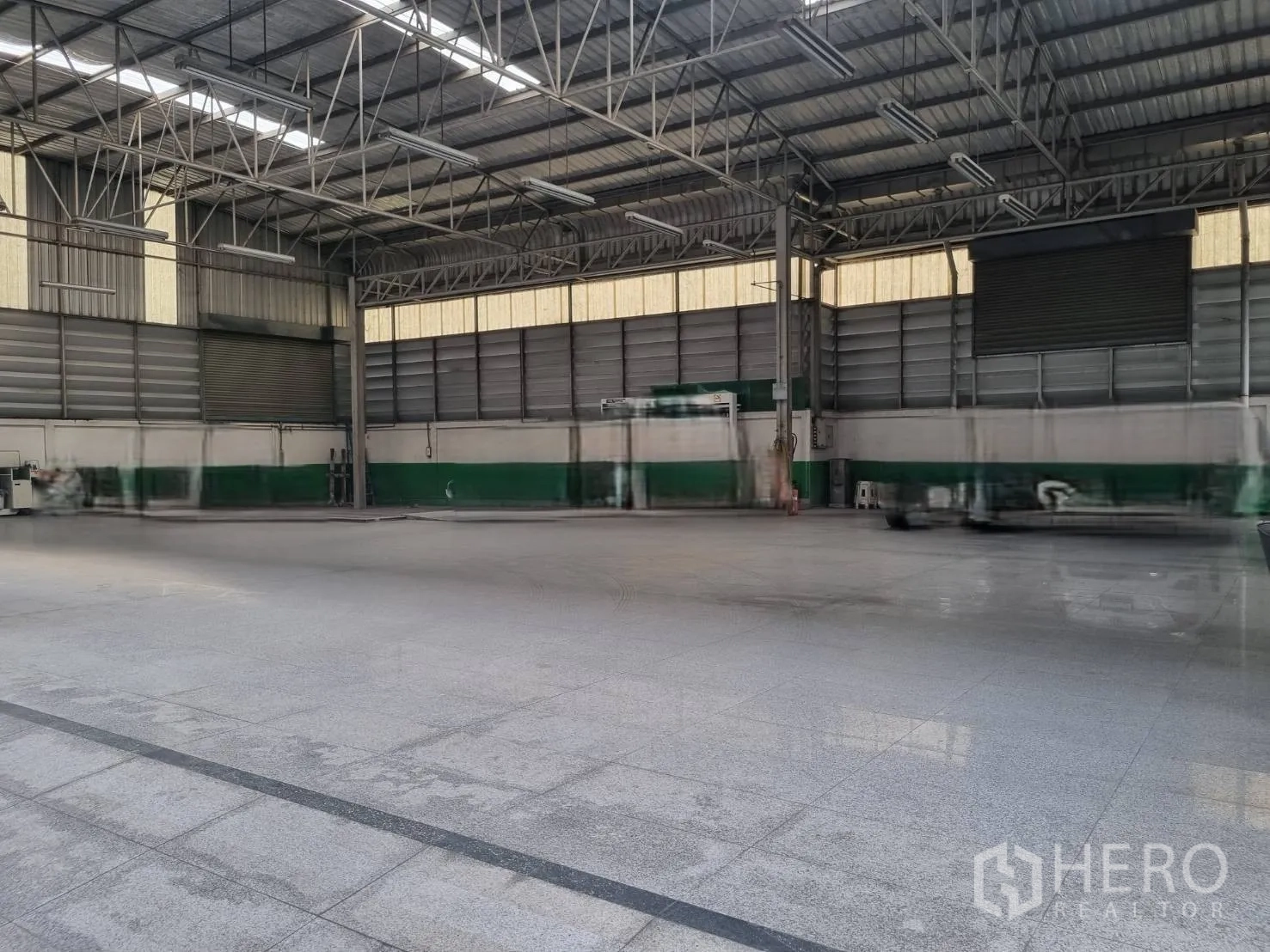 Warehouse for sale in Yan Nawa, Bangkok - Spacious warehouse interior with steel truss roof, bright lighting, roller shutters, and smooth flooring.