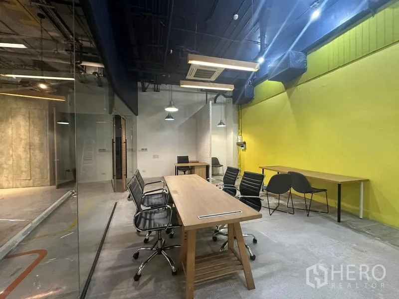 สำนักงาน ให้เช่า - โซนประชุม โต๊ะยาว โคมแขวน และผนังเน้นสีเหลืองสด