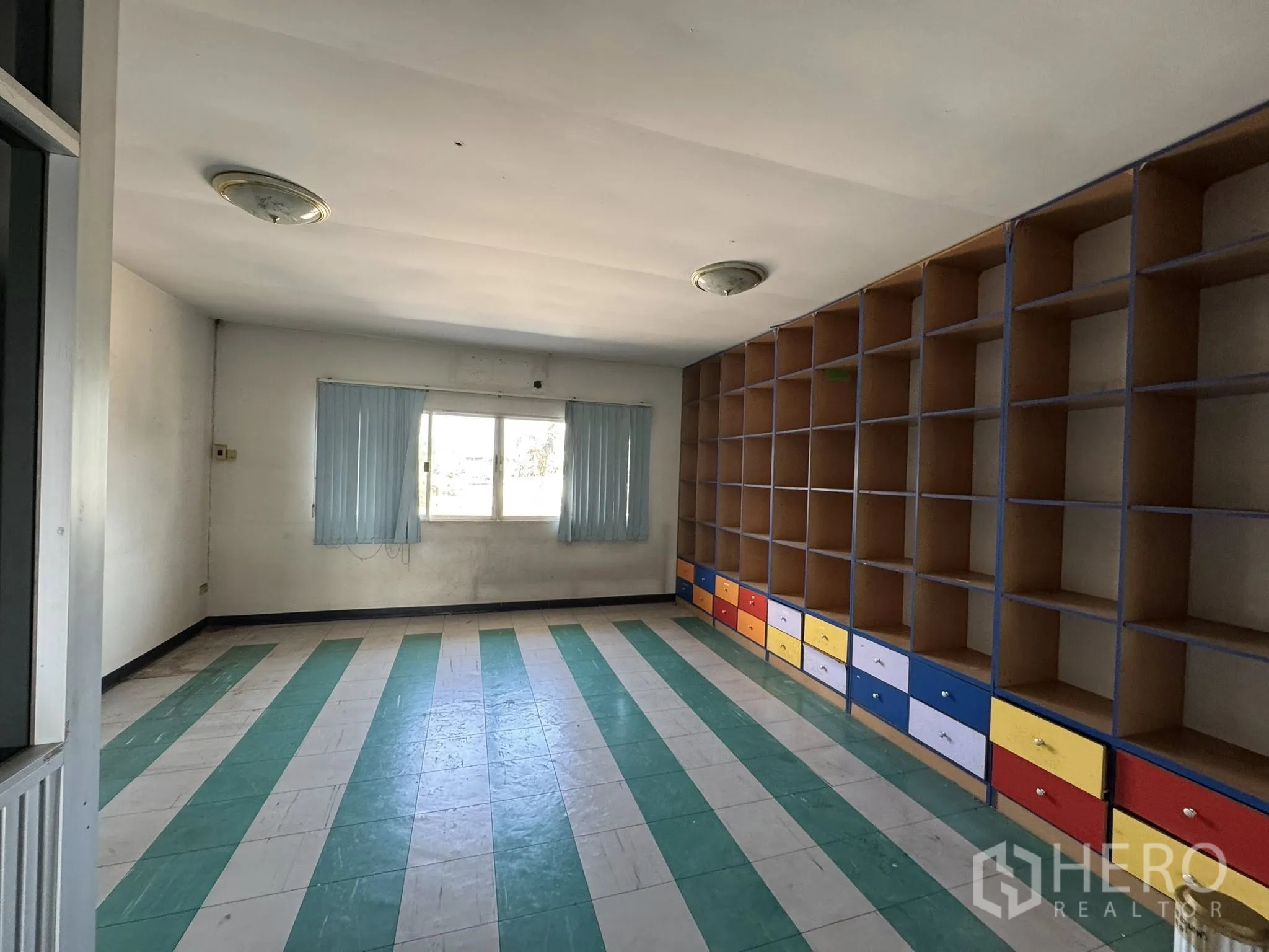 คลังสินค้า for rent in Mueang Samut Sakhon, Samut Sakhon - ห้องทำงานมีตู้ชั้นและลิ้นชักสีสันสด พื้นไวนิลลายทางเขียวขาว