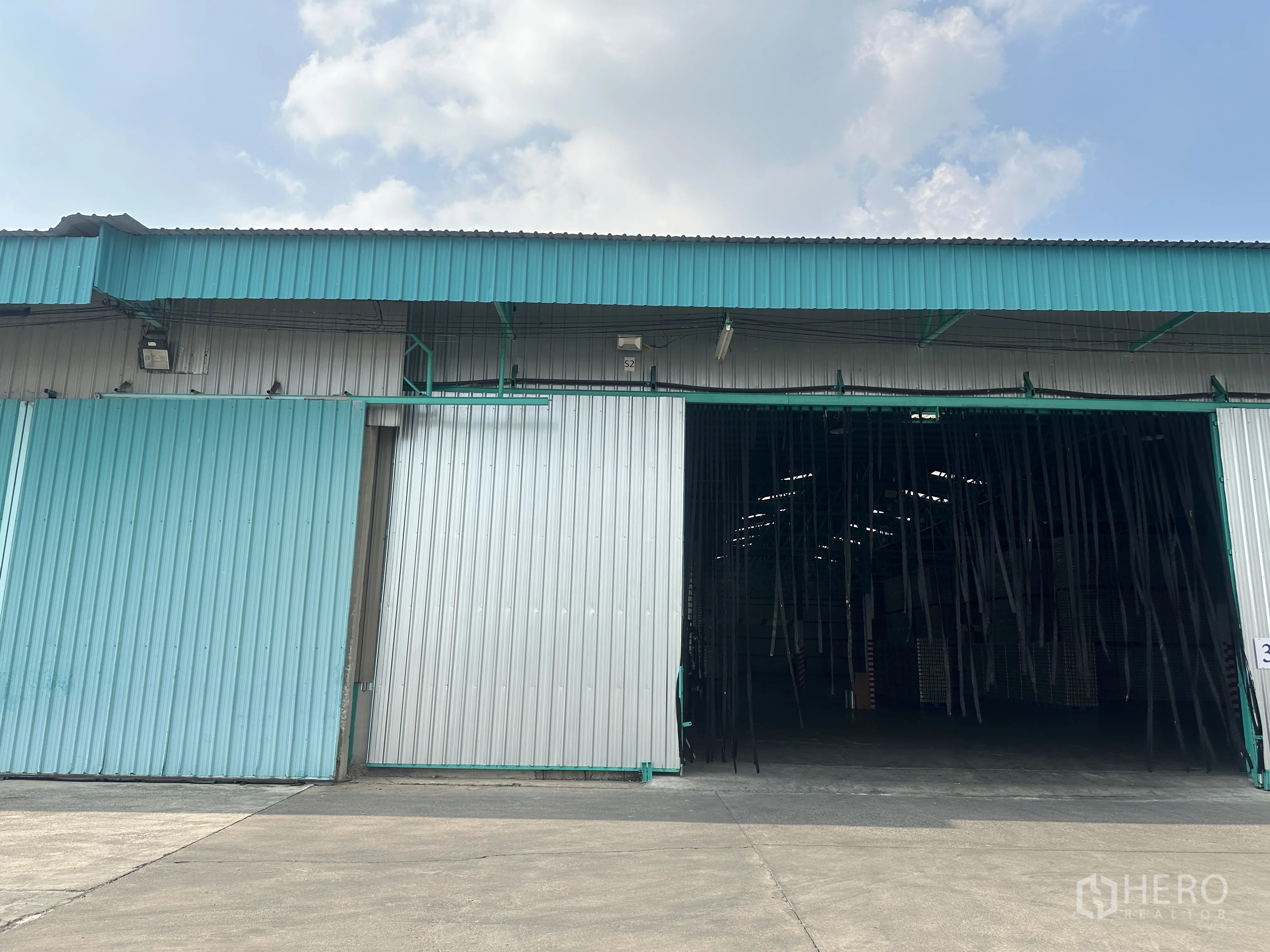 Warehouse for rent in Mueang Pathum Thani, Pathum Thani - Metal-clad warehouse exterior with wide sliding doors and spacious driveway in Bang Khayaeng, Mueang Pathum Thani.