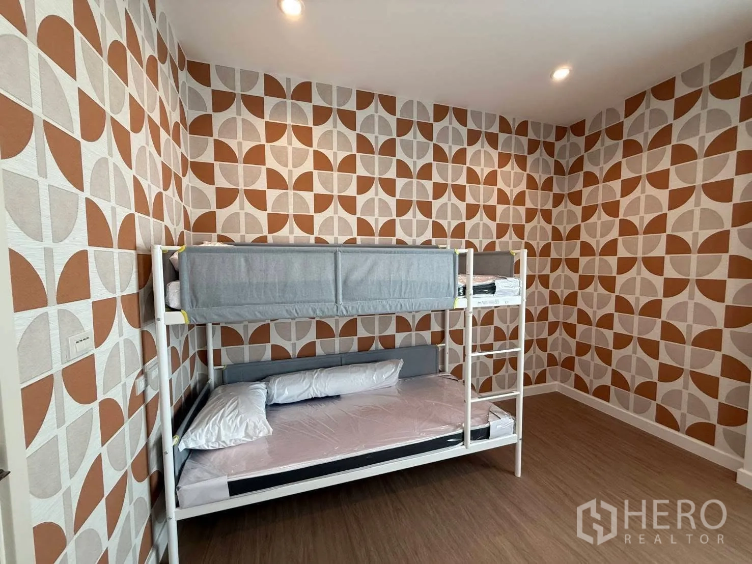 独栋房屋 for rent in Bang Phli, Samut Prakan - 卧室配几何图案墙纸与白色金属双层床。