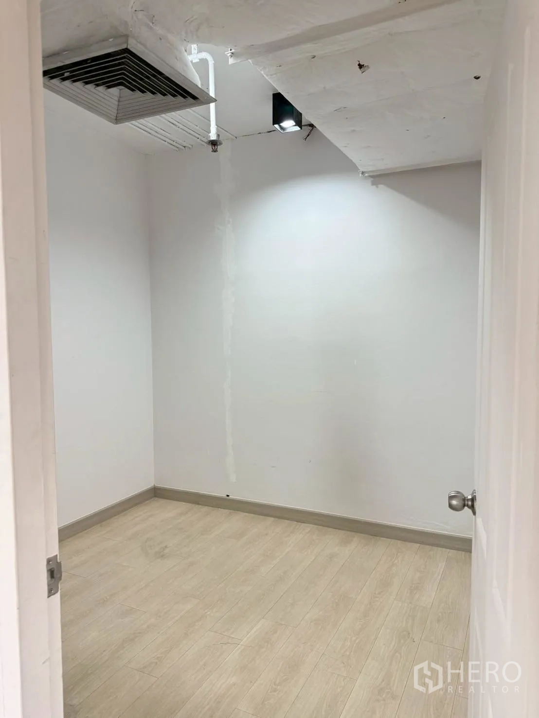 办公室 for rent in Watthana, Bangkok - 小型白色房间，浅色木纹地板与天花通风口。