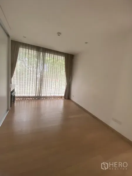 公寓 出租在Pathum Wan, Bangkok - 明亮卧室，木地板，大窗配窗帘，树梢景观