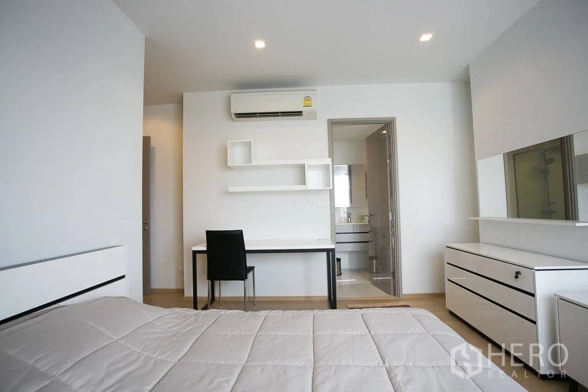 公寓 出租在Watthana, Bangkok - 卧室视角可见书桌与带卫生间的套房布局。