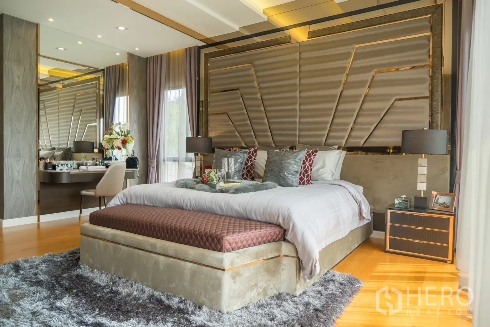 Detached House for rent in Prawet, Bangkok - Primary bedroom with padded feature wall, king bed, warm wood floors and soft lighting