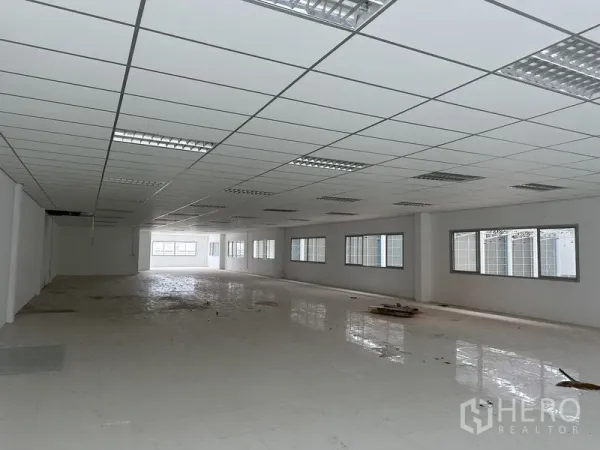Factory for rent in Pathum Thani - Long open-plan office area with multiple side windows and tiled floor.