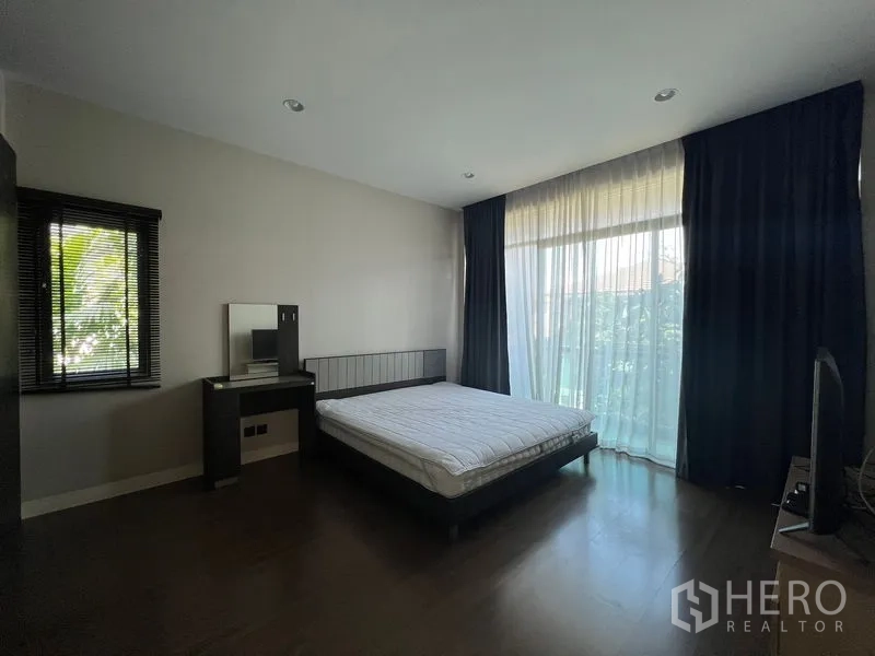 Detached House for rent or sale in Bang Kapi, Bangkok - Bedroom with vanity table, side window and floor-to-ceiling drapes.