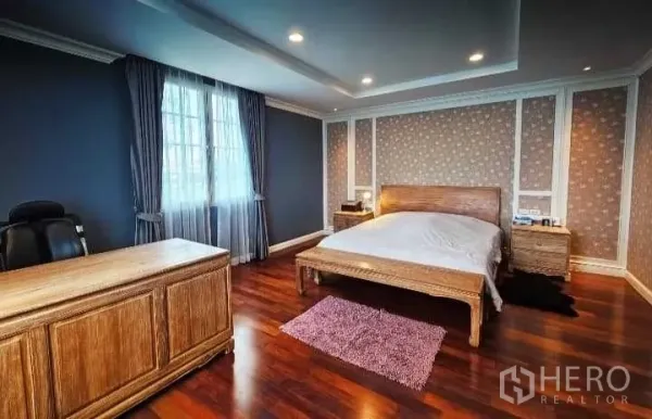 独立式住宅 出售在Phra Khanong, Bangkok - 宽敞卧室，书桌、大窗配窗帘、嵌入式顶灯与木质家具。
