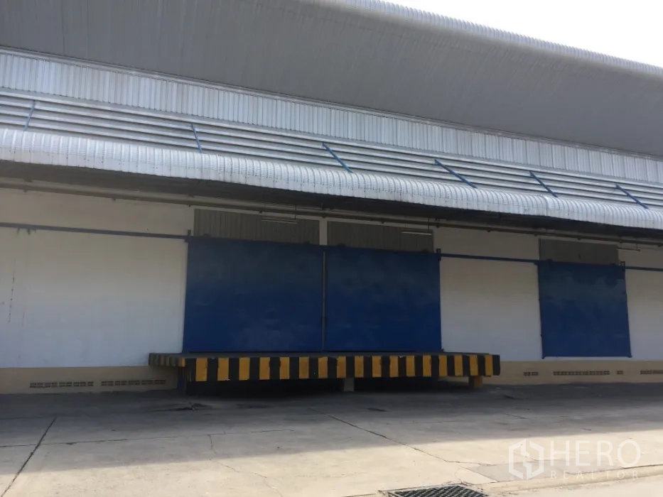 货栈 出租在Lat Krabang, Bangkok - 位于曼谷Lat Krabang的仓库外观，带雨棚的高位装卸月台与蓝色大门。