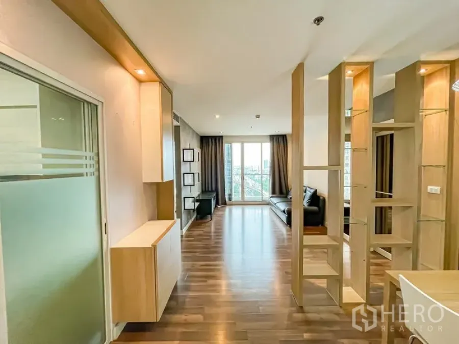 Condominium for sale - Entrance corridor toward balcony-lit living room with wooden dividers.