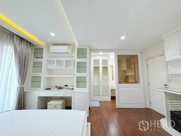 Townhouse for rent in Phra Khanong, Bangkok - Bright master bedroom with built-in desk, shelving and glass wardrobes.