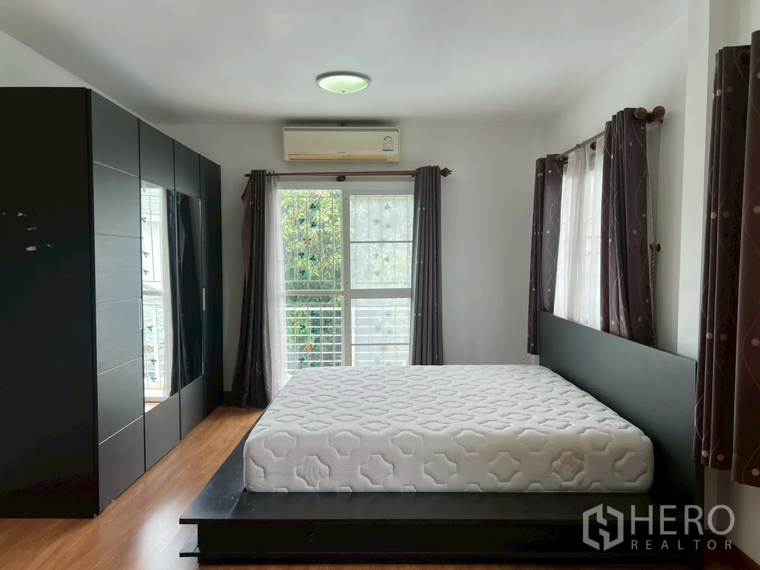 บ้าน ขายในMin Buri, Bangkok - ห้องนอนมาสเตอร์ เตียงฐานล่าง ตู้เสื้อผ้าสีดำ