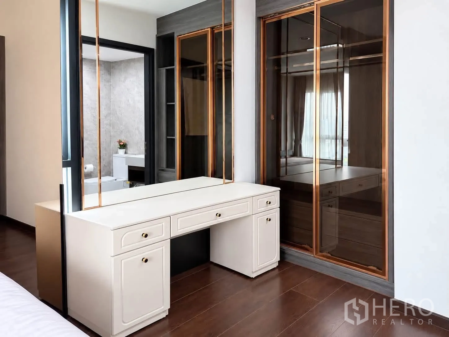 Condominium for rent in Watthana, Bangkok - Bedroom dressing zone with vanity and mirrored wardrobes next to the bathroom.