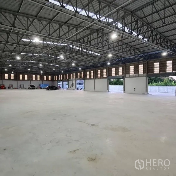货栈 出租在Prawet, Bangkok - 仓库内景，多个卷闸装卸门通向外部场地