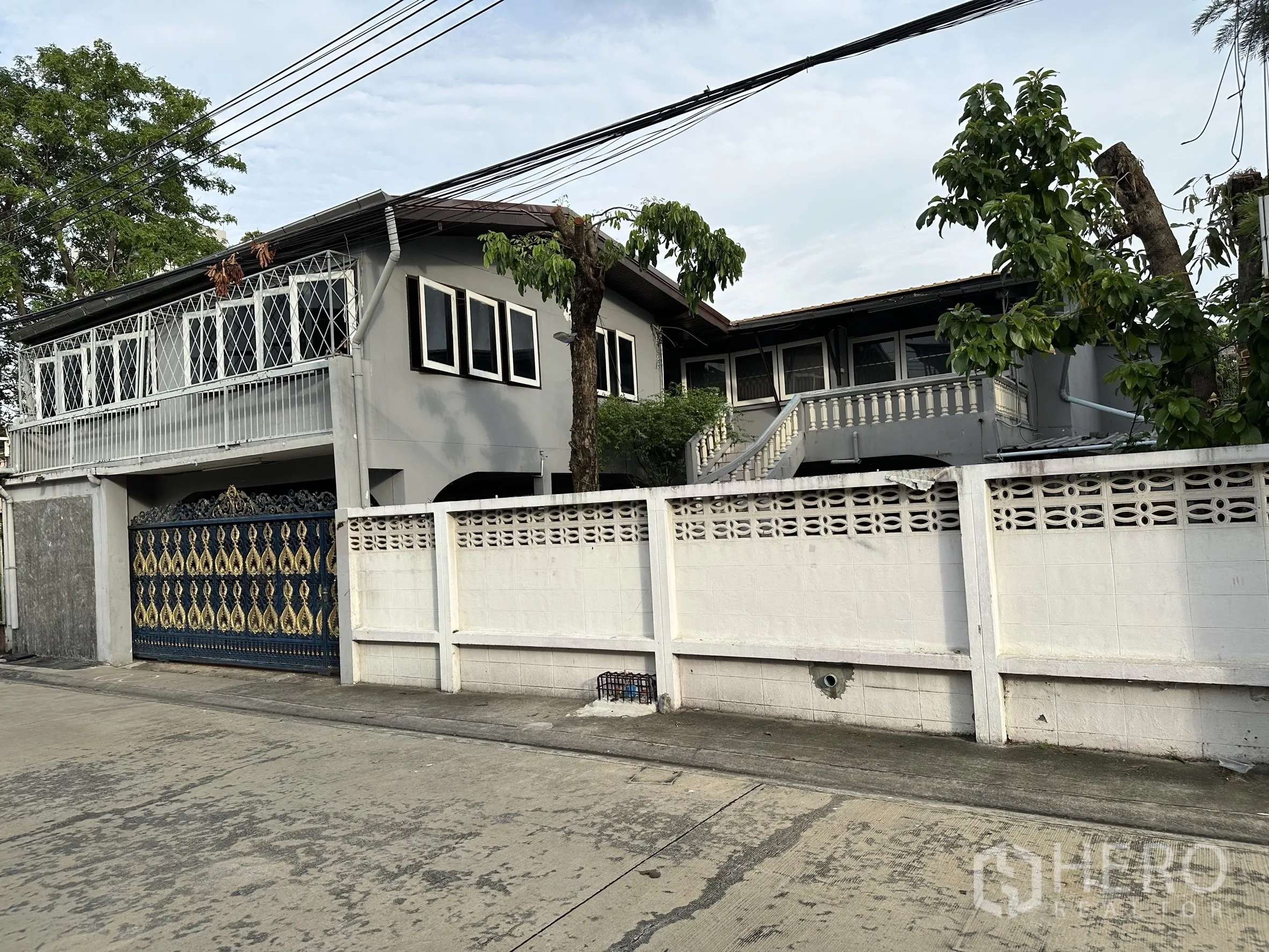 Home Office for rent in Suan Luang, Bangkok - Two-storey home office exterior with white perimeter wall, balcony and trees.