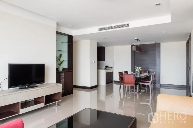 Apartment for rent in Khlong Toei, Bangkok - Bright open-plan living and dining room with TV console, tiled floors and balcony access.