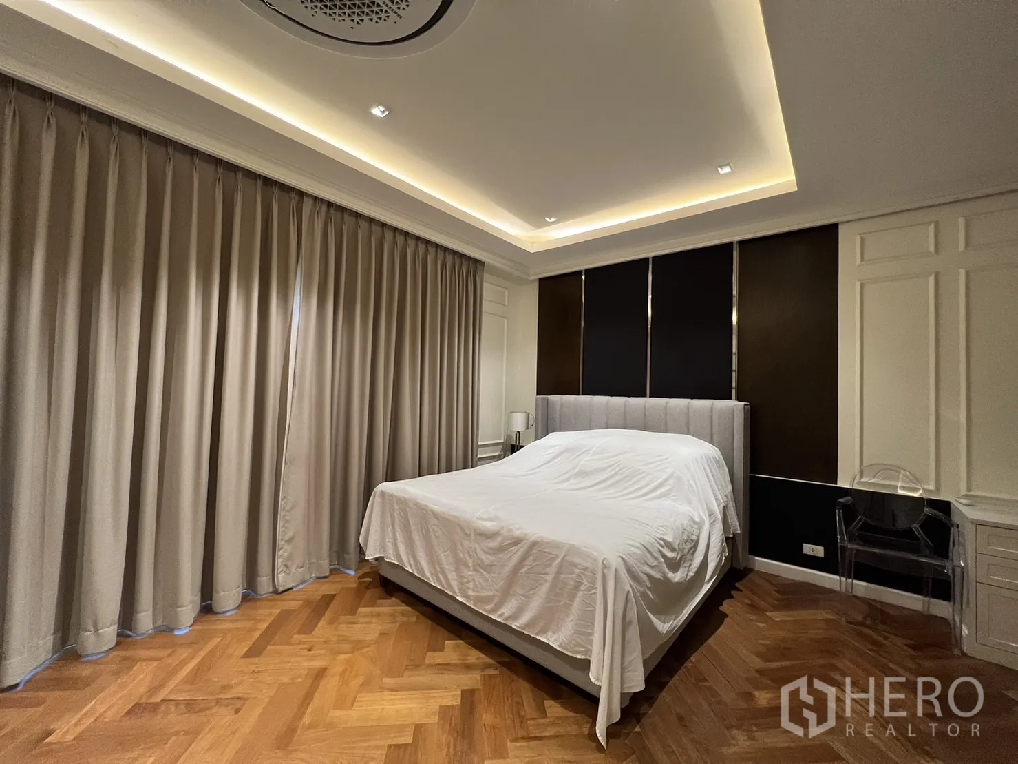 บ้าน ให้เช่าในSuan Luang, Bangkok - ห้องนอนมีเตียงบุผ้า ผนังตกแต่งสีเข้มและผ้าม่านทึบ