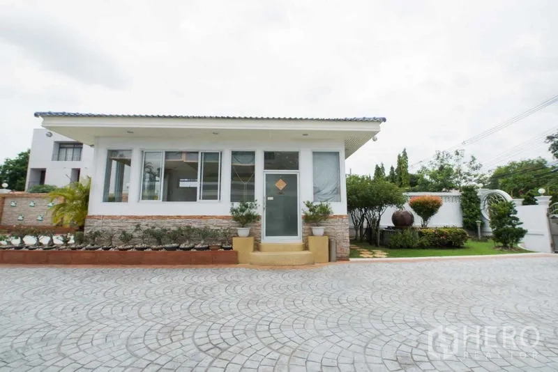 Detached House for rent or sale in Bang Kapi, Bangkok - Single-storey annex or office facing landscaped lawn and stone driveway.