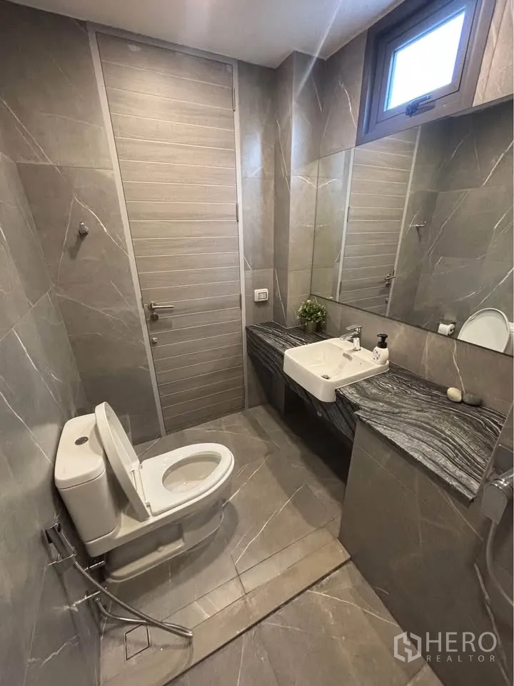家庭办公室 for rent or sale in Suan Luang, Bangkok - 现代灰色石纹瓷砖浴室，配坐便器与墙挂式台盆。