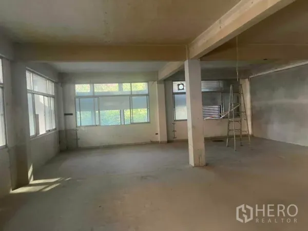 带办公室的家 出租在Watthana, Bangkok - 宽敞空置的办公楼层，转角窗、支撑柱及一把梯子，毛坯空间。