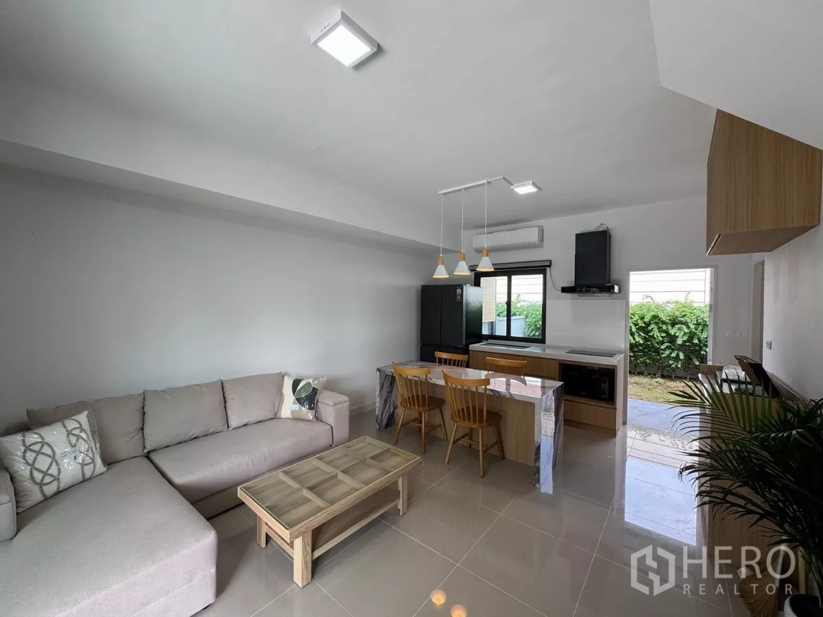 Townhouse for rent in Bang Phli, Samut Prakan - Bright living area with pendant lights and sliding door leading to the backyard.