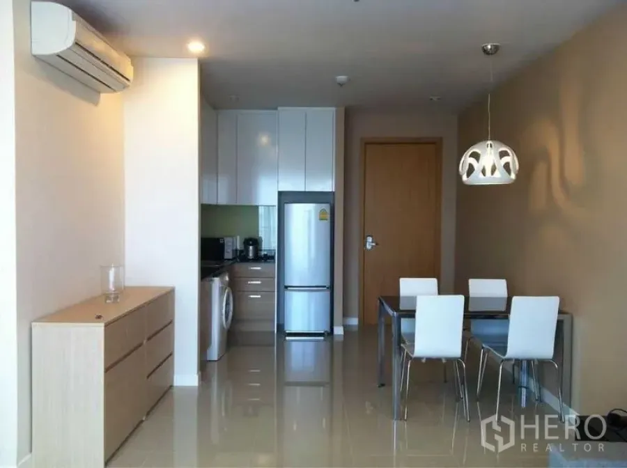 公寓 出售在Ratchathewi, Bangkok - 开放式厨房与餐区，亮面地砖、冰箱、洗衣机及白色四人餐桌与吊灯。