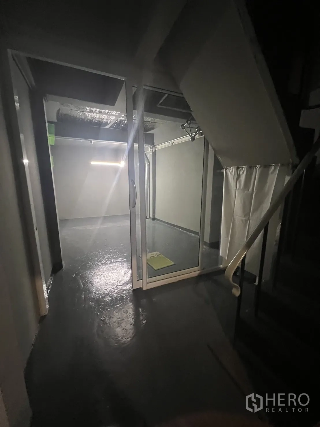 Shophouse for rent in Watthana, Bangkok - Ground-floor hallway with glass enclosure beneath stairs.
