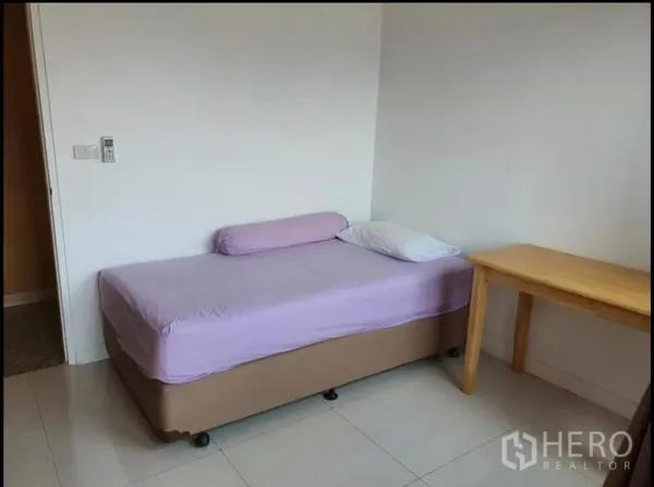 公寓 出租在Ratchathewi, Bangkok - 明亮卧室，单人床、木桌与瓷砖地面。
