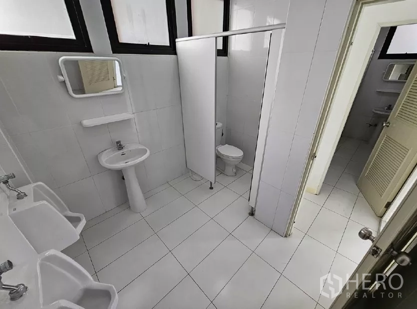 Warehouse for rent or sale in Lak Si, Bangkok - Clean tiled restrooms with stalls, urinals and sinks