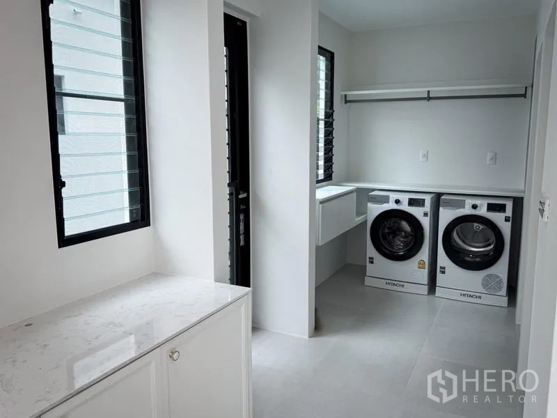 Detached House for rent or sale - Laundry room with two front-load machines, cabinetry, and windows.