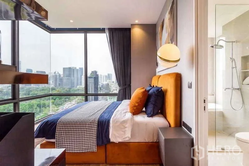 Condominium for rent in Pathum Wan, Bangkok - Ensuite bedroom with corner windows and access to a bright bathroom.