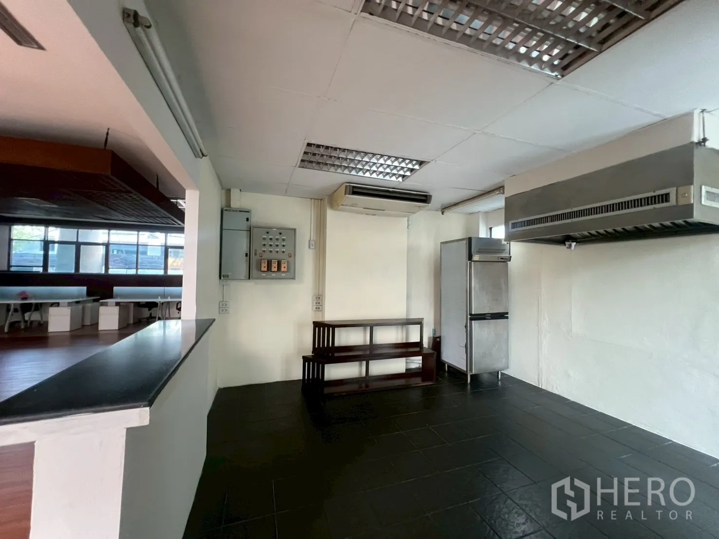 Retail Space for rent - Preparation area with extractor hood, tiled floor and opening to the sales space.