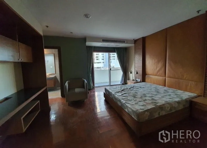 คอนโด ให้เช่าในWatthana, Bangkok - ห้องนอนใหญ่ เตียงคิง ผนังหัวเตียงบุหนัง และประตูกระจกสไลด์ออกระเบียง