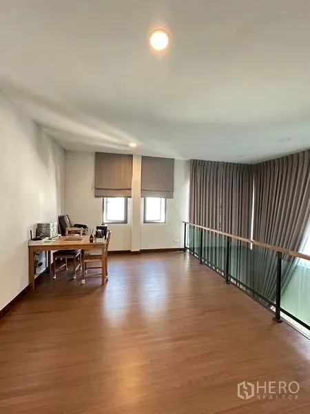 Detached House for rent in Bang Phli, Samut Prakan - Mezzanine home office with wood flooring, desk and glass balustrade overlooking the lounge.