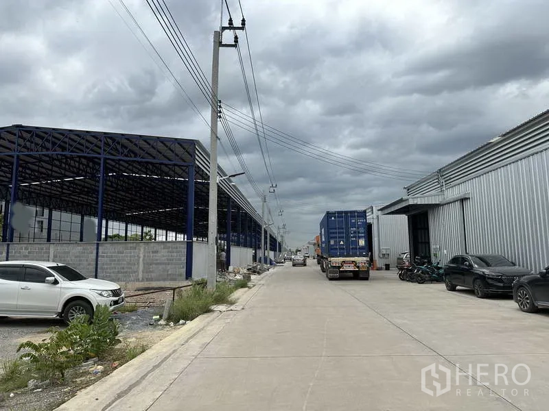 货栈 出租在Lat Krabang, Bangkok - 两侧为仓库的宽阔通道，电力线沿街，集装箱卡车进出与掉头方便。