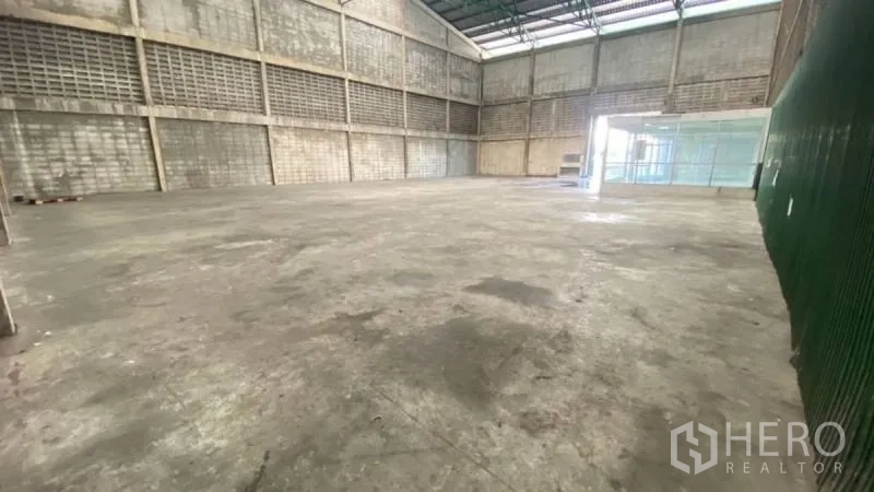 Warehouse for rent in Prawet, Bangkok - Open industrial floor with high-clearance ceiling, ventilated block walls and clean concrete surface for loading and storage.