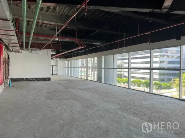 Retail Space for rent in Bang Rak, Bangkok - Bright retail shell with full-height windows, city views and visible fire-sprinkler pipes.