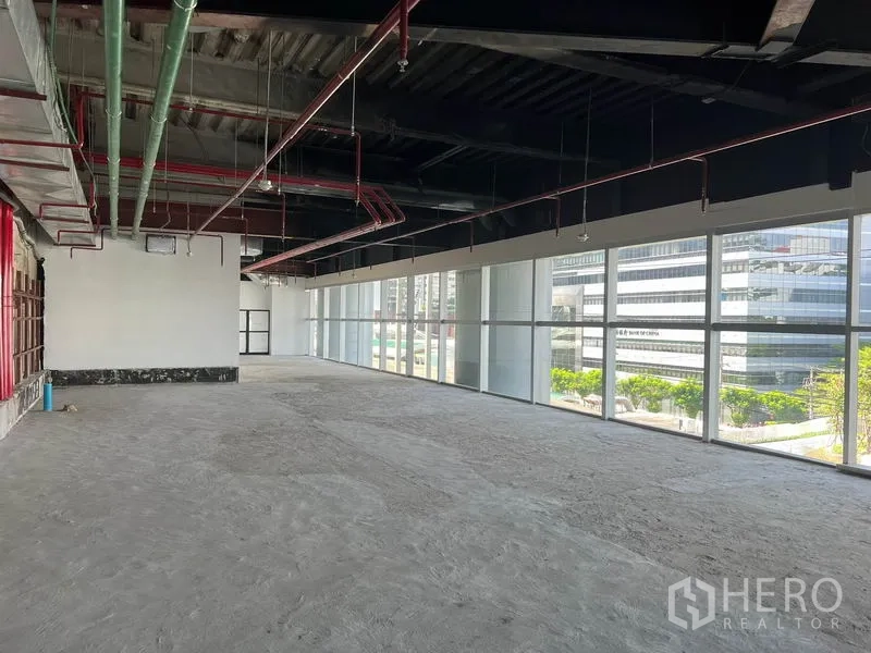 Retail Space for rent in Bang Rak, Bangkok - Bright retail shell with full-height windows, city views and visible fire-sprinkler pipes.