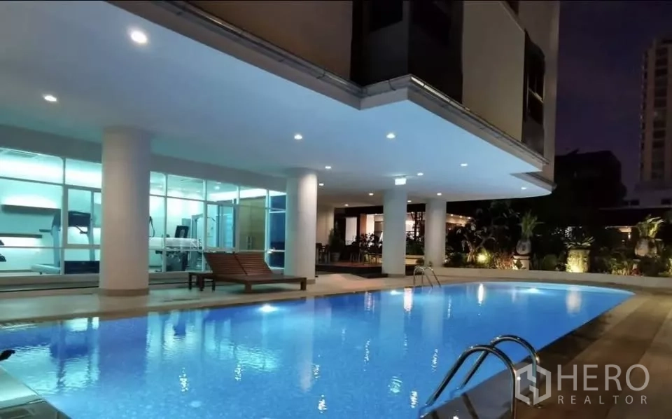 公寓 出租在Pathum Wan, Bangkok - 夜间泳池，旁连健身房与躺椅。