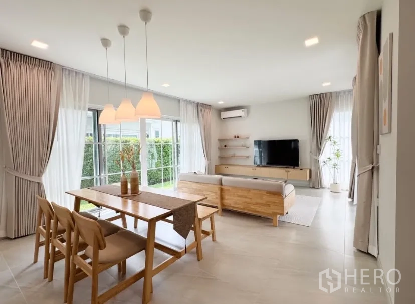บ้าน ให้เช่าในBang Phli, Samut Prakan - โซนรับแขกและทานอาหารแบบโอเพน พร้อมโคมไฟห้อยและประตูบานเลื่อนบานใหญ่